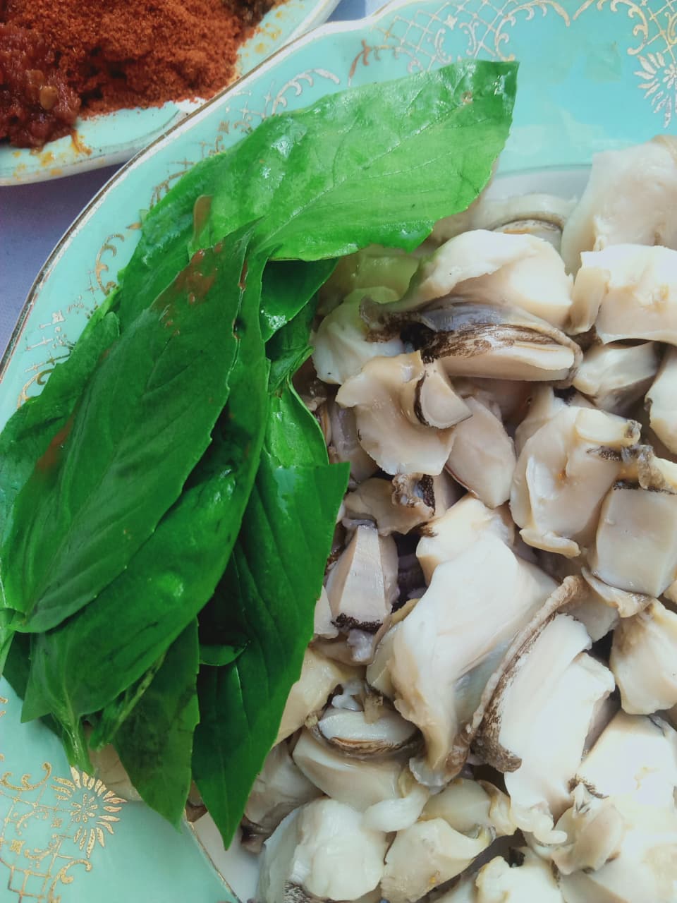 Raw Murex tissue with fresh basil